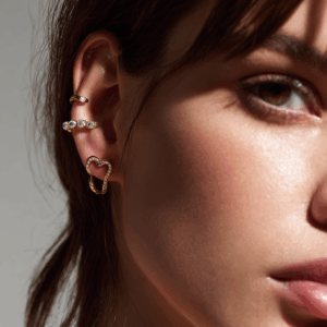 Doble piercing oreja tendencia en el lóbulo con joyería dorada